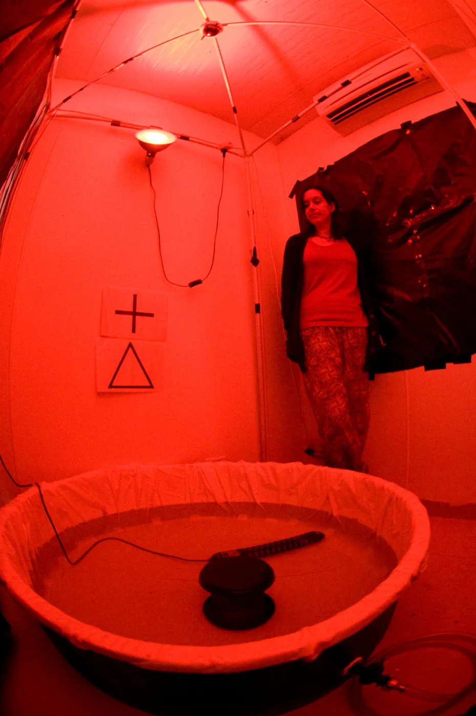 Researcher beside a toad behavioural testing arena under red lighting