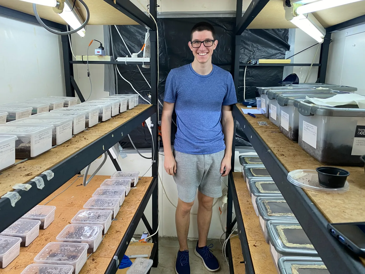 Researcher in the animal room surrounded by tubs and shelving