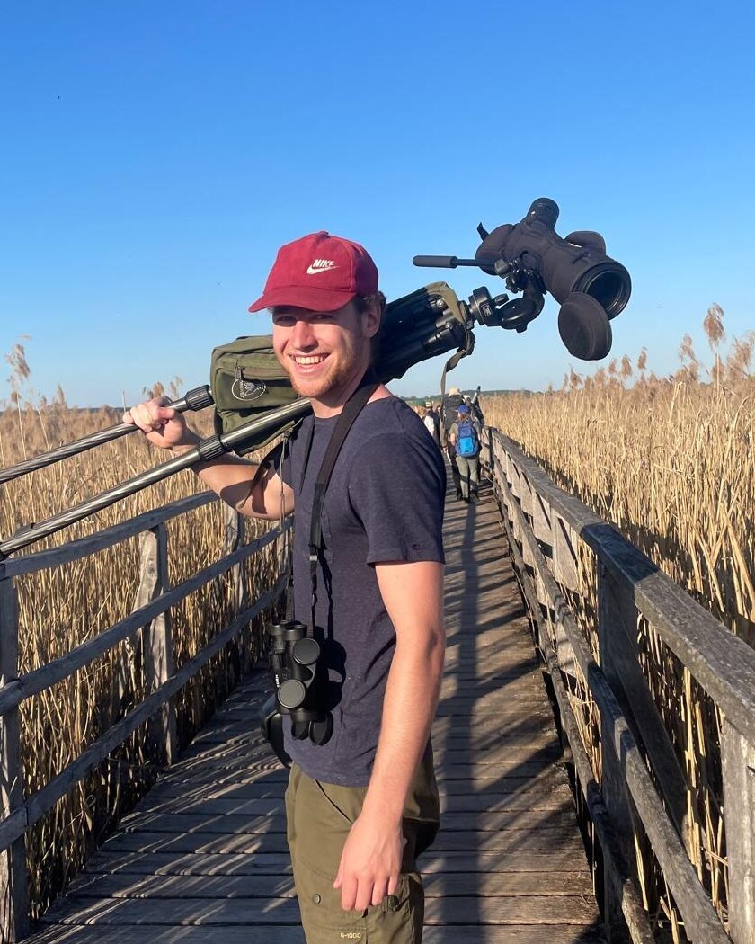 Simon Jeni carrying wildlife photography equipment in the field